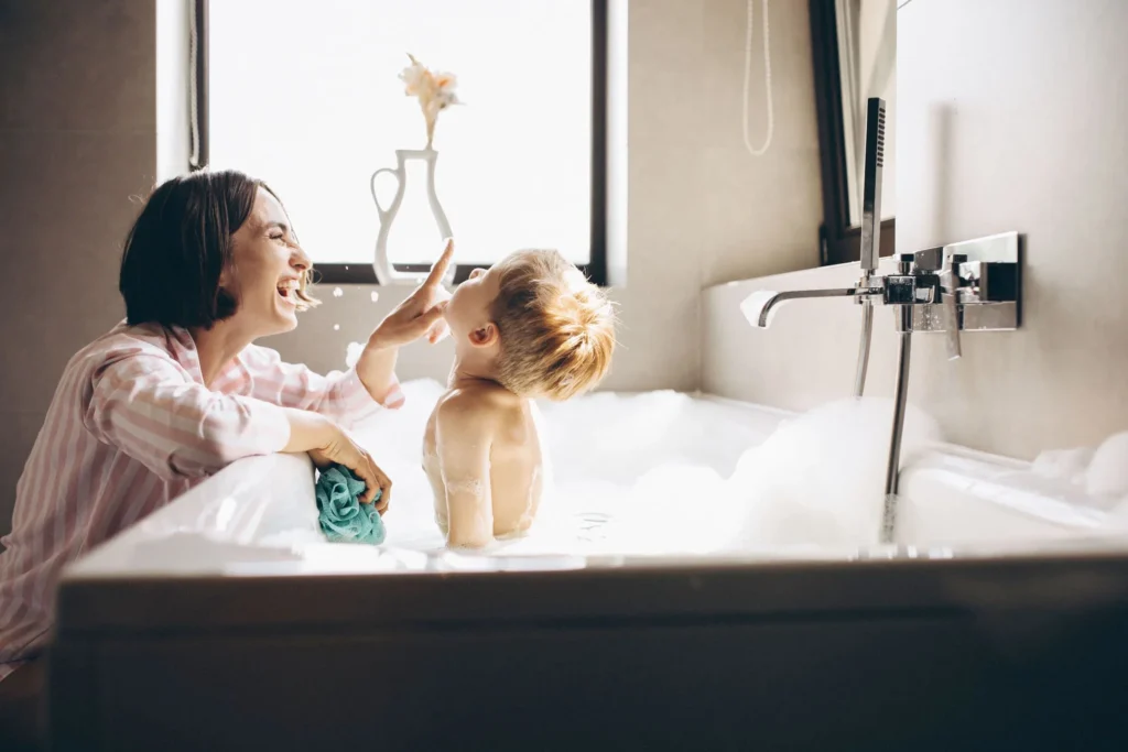 Smiling Mother Giving Young Son Bubble Bath Green Wash Cloth Remodeled Bathtub